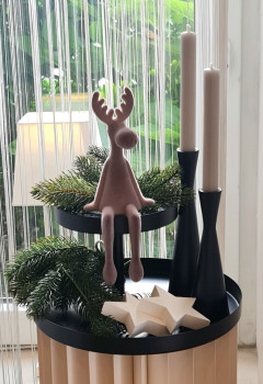Zweistufige Etagere aus schwarzem Metall mit dezentriertem Design auf hellem Holztisch