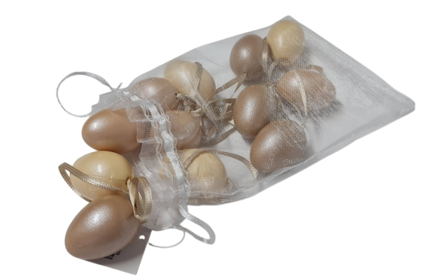 Osterdeko aus kleinen Kunststoff-Ostereiern in natürlichen Farben auf einem dekorierten Tisch.