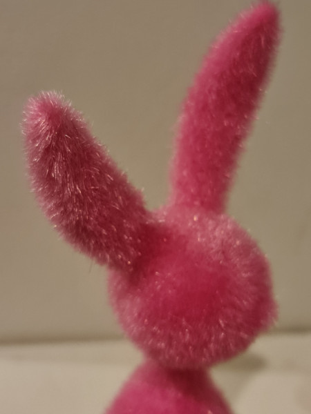 Moderner Deko Sitzhase schwarz mit langen Fasern auf Regal platziert