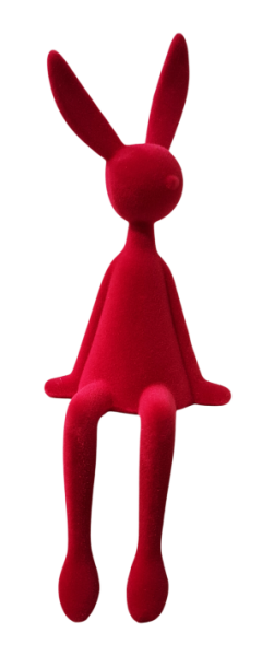 Pinkfarbener Kantenhocker Osterhase mit samtiger Beflockung sitzend auf einer Fensterbank