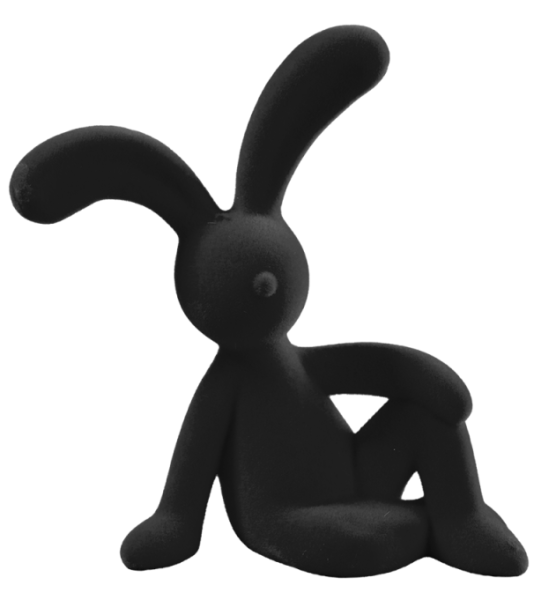 Schwarzer beflockter Osterhase in entspannter Sitzpose, seitlich sitzend und mit einem Arm am Knie abgestützt