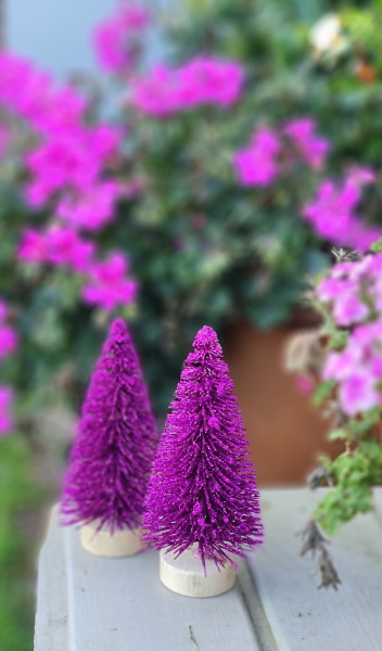 Dekorativer pinker Tannenbaum aus Kunststoff auf Holzbasis – festliche Weihnachtsdekoration.